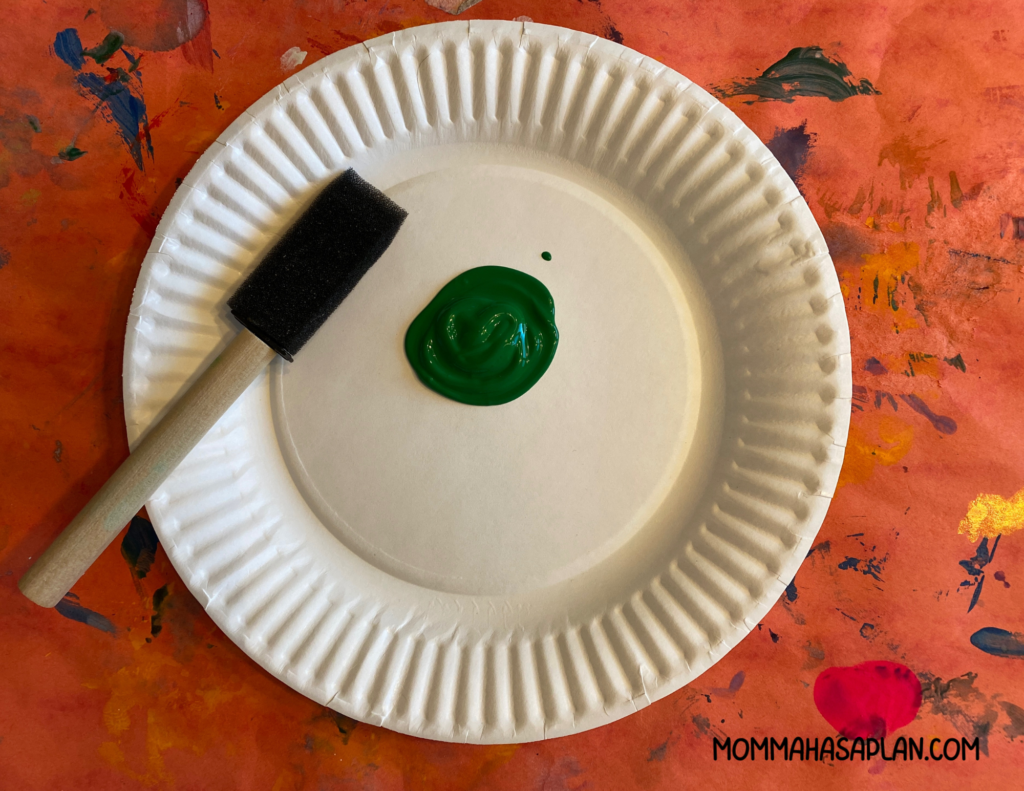 Add green paint to plate for 1-year-olds