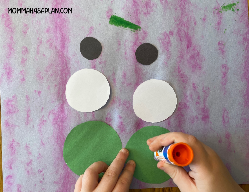 Assembling the eyes of your paper plate frog craft