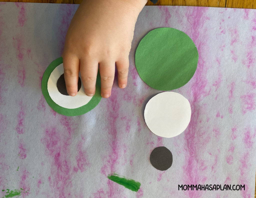 Assembling the eyes of your paper plate frog craft