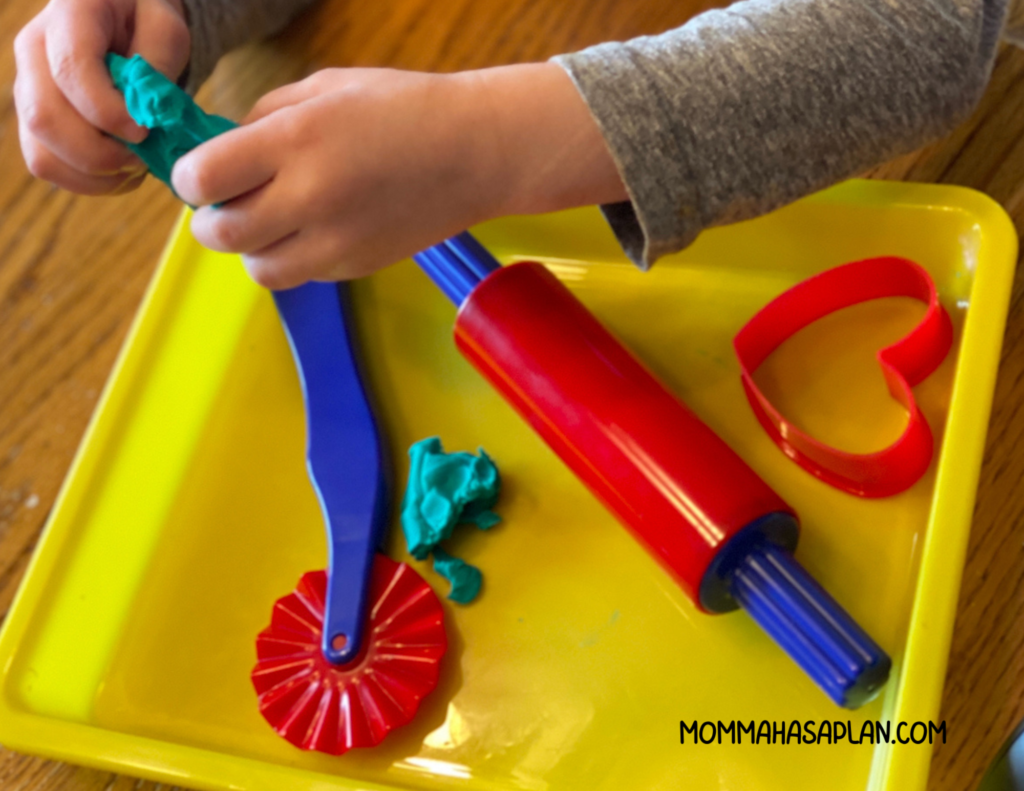 1-year-old squishing playdough with fingers