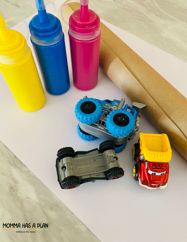 materials for painting with toy cars. paint, paper, cars, kraft paper to cover table top