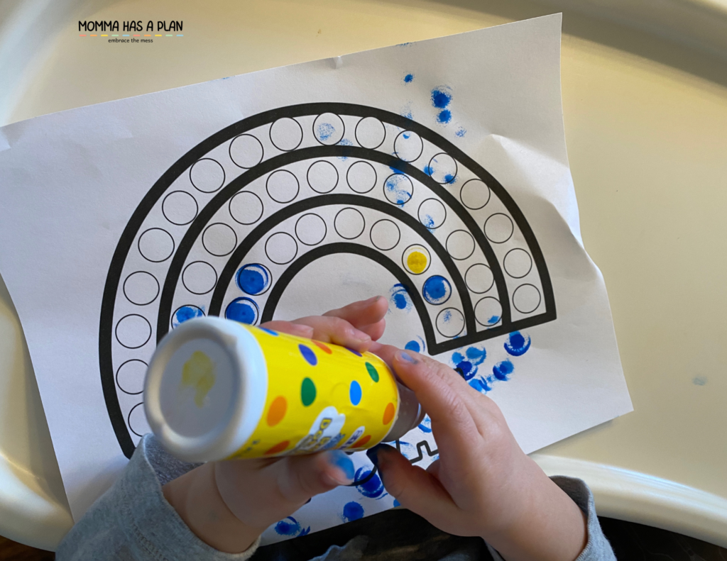 1-year-old using do-a-dot markers to create a rainbow